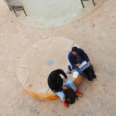 Two workers sit together with a computer.