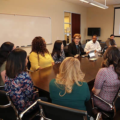 Business professionals work around a conference table.