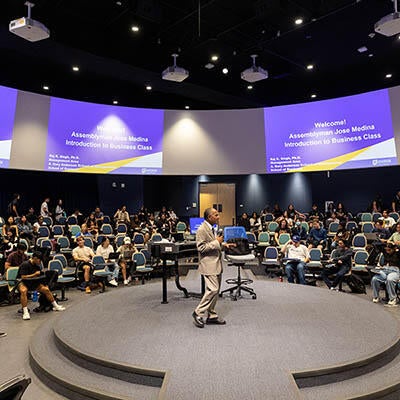 A man speaks in front of a crowd at a conference.