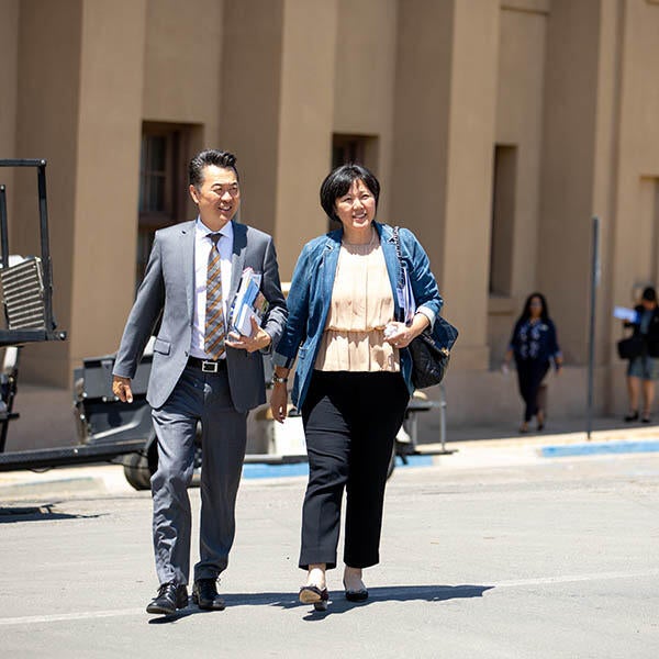 Two business people walk together on the UC Riverside campus.