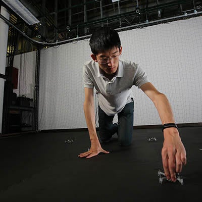 A young technician works on a robot.