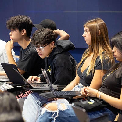 Young workers sit together working on computers.